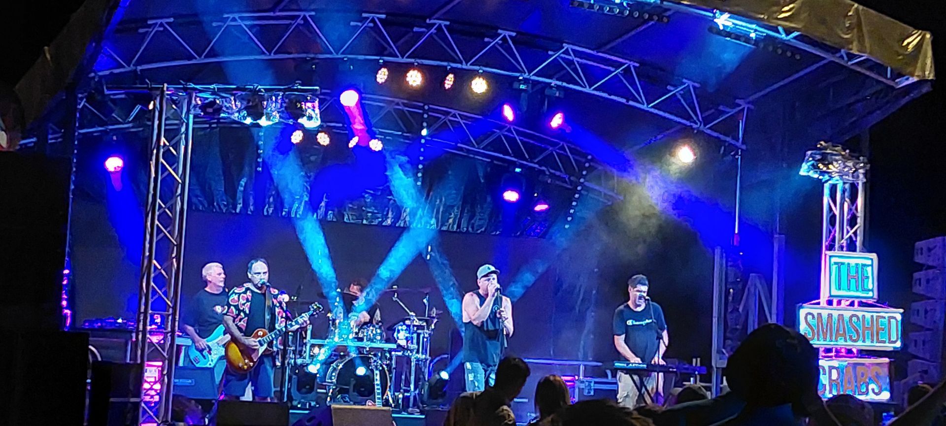A group of people are standing on a stage at a concert.