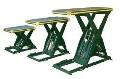 Three green scissor-lift tables with yellow tops at different heights