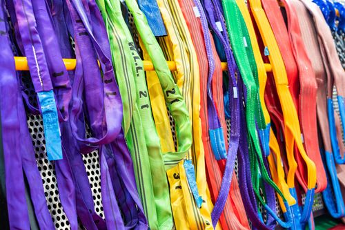 Colorful woven ribbons and fabric strips hanging in a dense, multicolored display