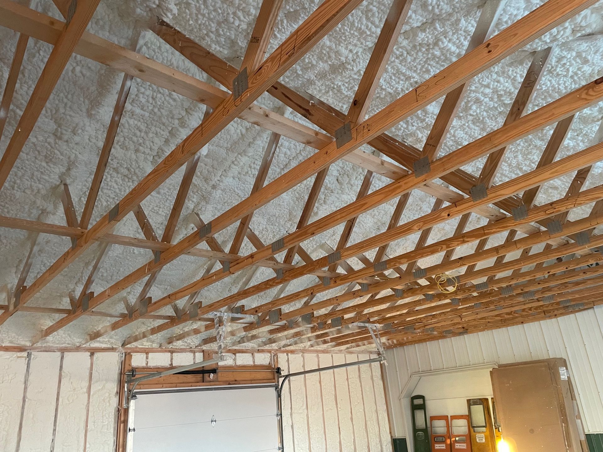 The ceiling of a building with wooden beams and foam on it.