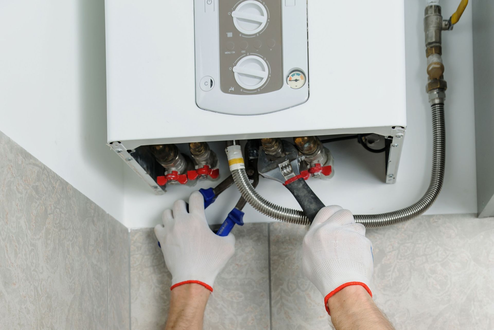 A person is fixing a water heater in a bathroom.
