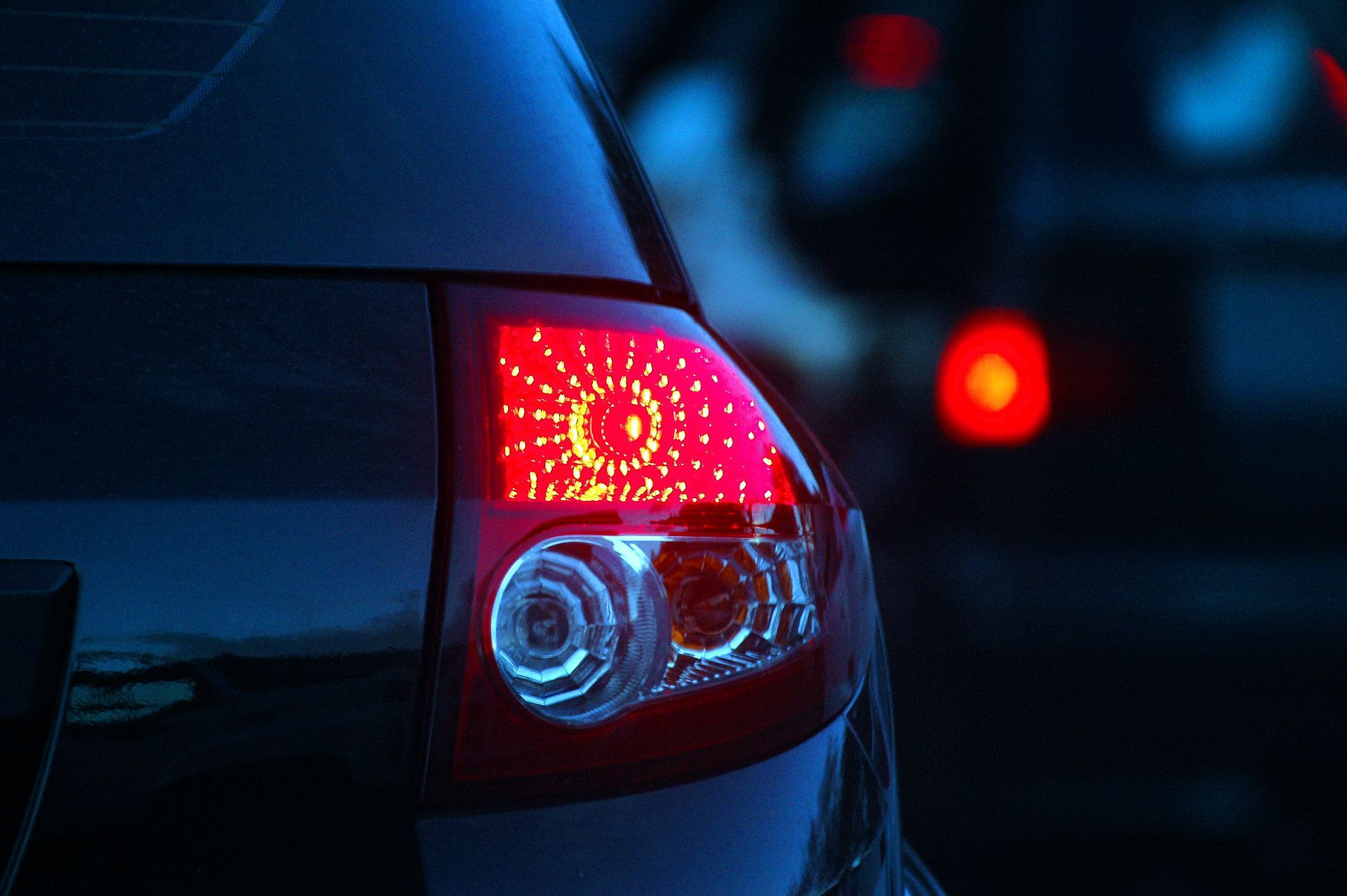 A close up of a car 's tail light at night.