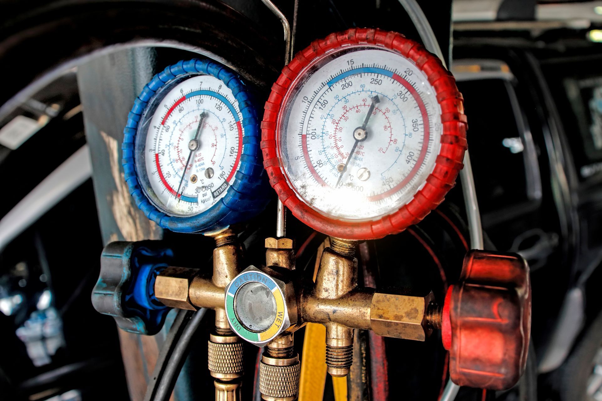 A couple of gauges hanging from a pole next to a car.