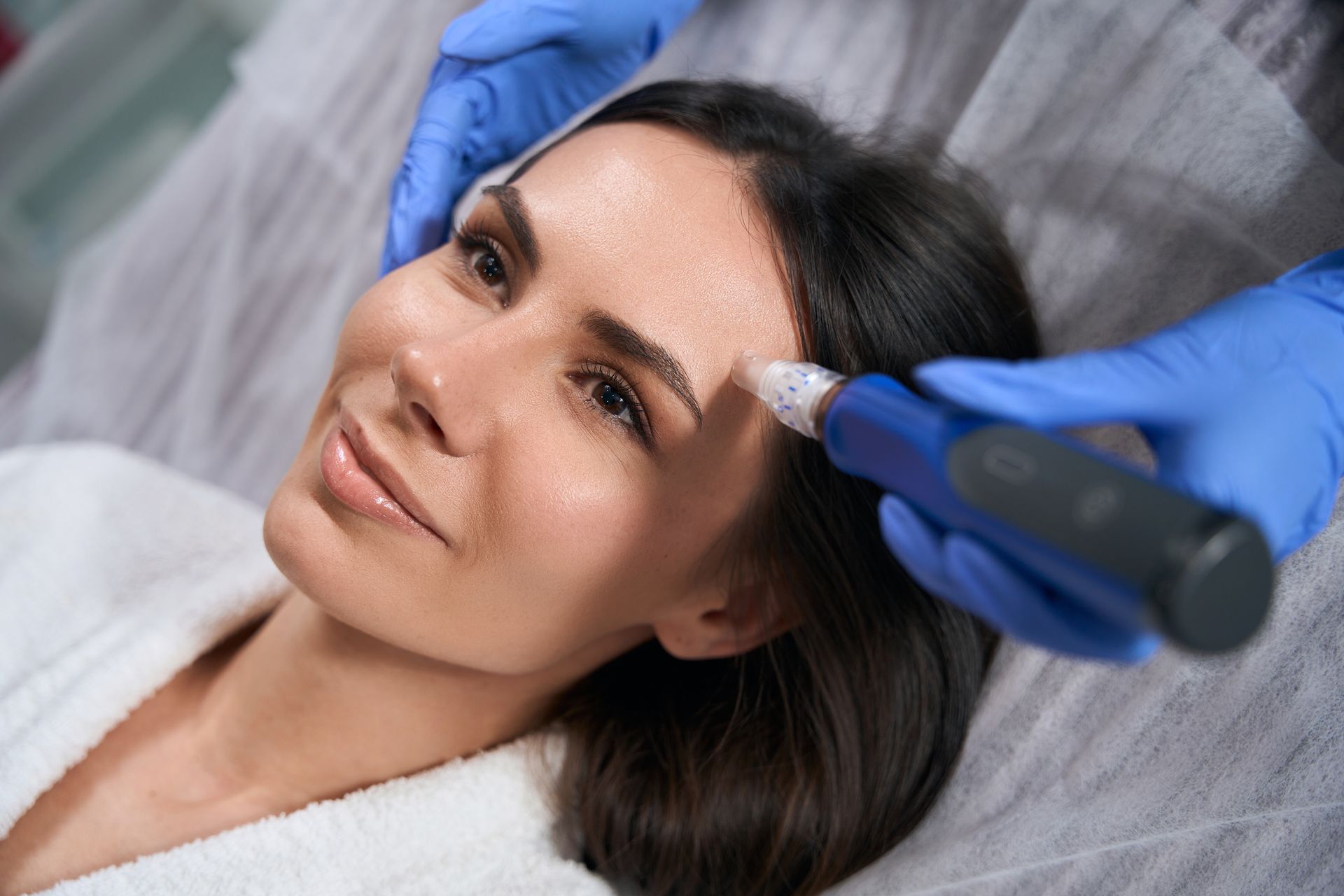 A woman is getting a hair treatment in a beauty salon.