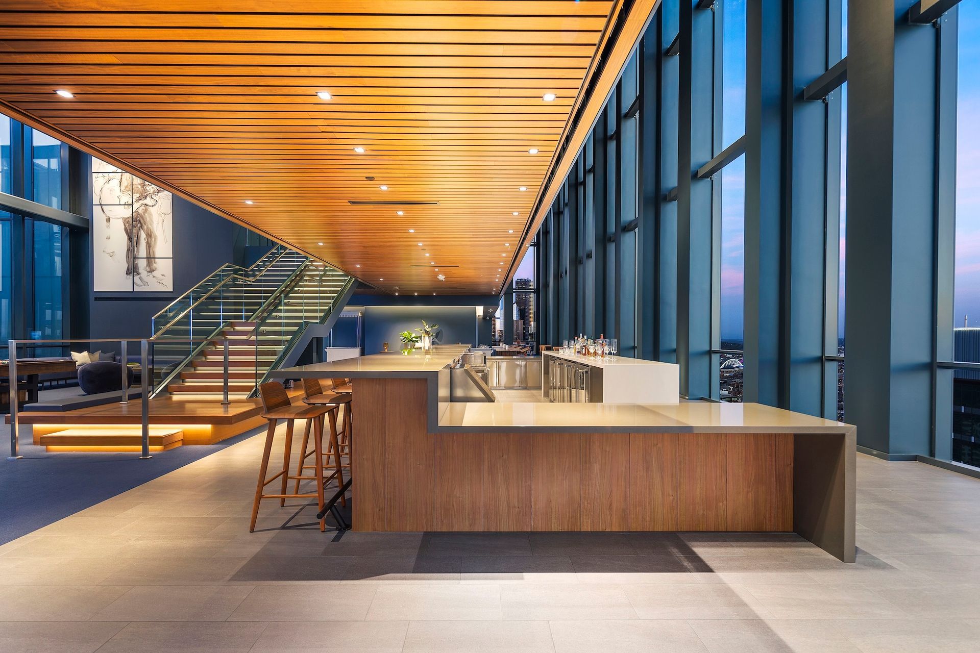 Modern office lobby with wood ceiling, glass walls, and a large reception desk.