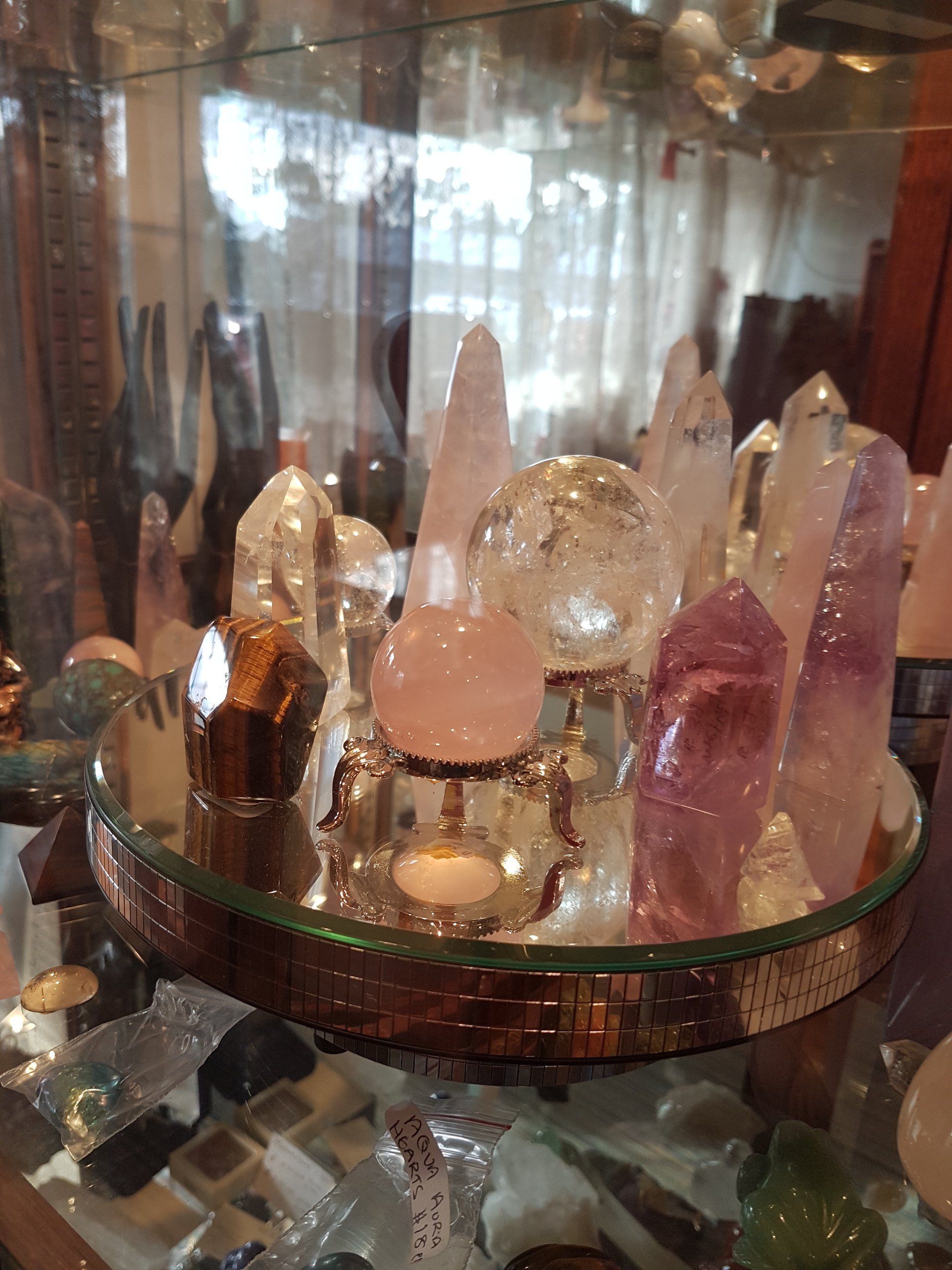 A glass display case filled with crystals and candles