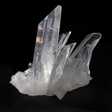 A close up of a crystal on a black background.