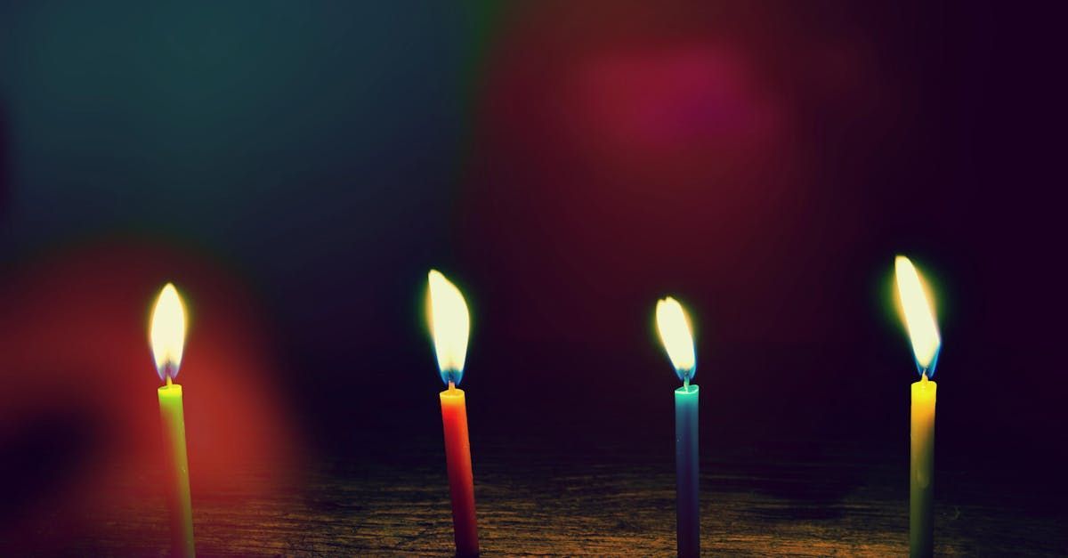 A row of lit birthday candles on a table.