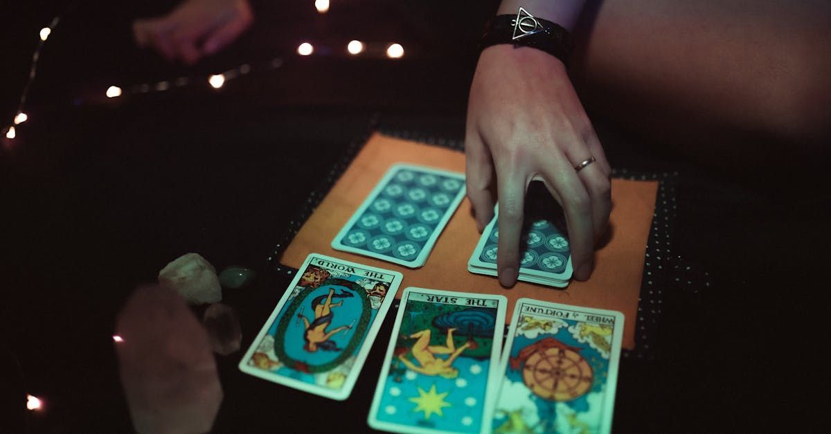 A person is playing tarot cards on a table.