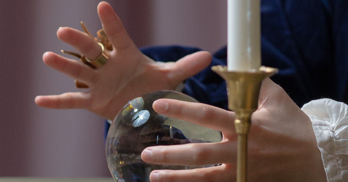 A person is holding a candle and a crystal ball.
