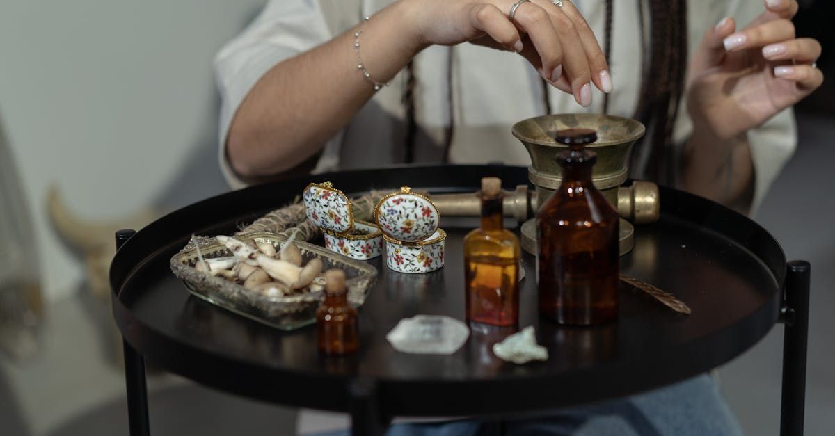 A woman is sitting at a table with a lot of bottles on it.
