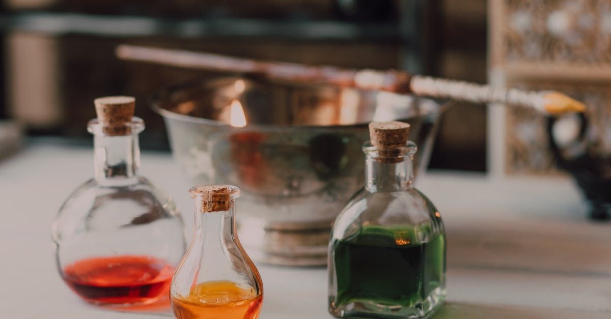 Three bottles of different colored liquids are sitting on a table.