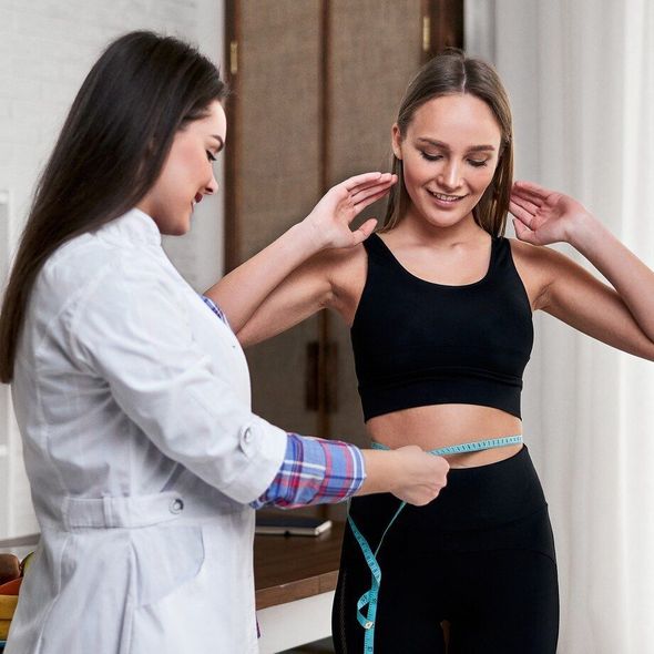 a woman is being measured by a doctor with a tape measure .