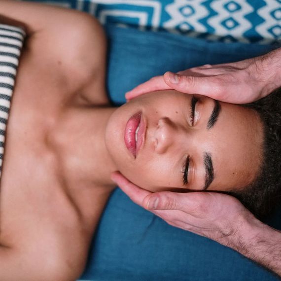 A woman is getting a head massage at a spa.