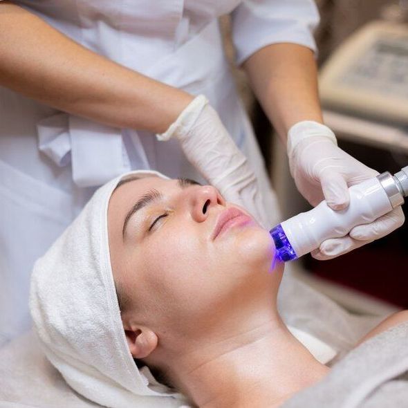 a woman is getting a treatment on her face