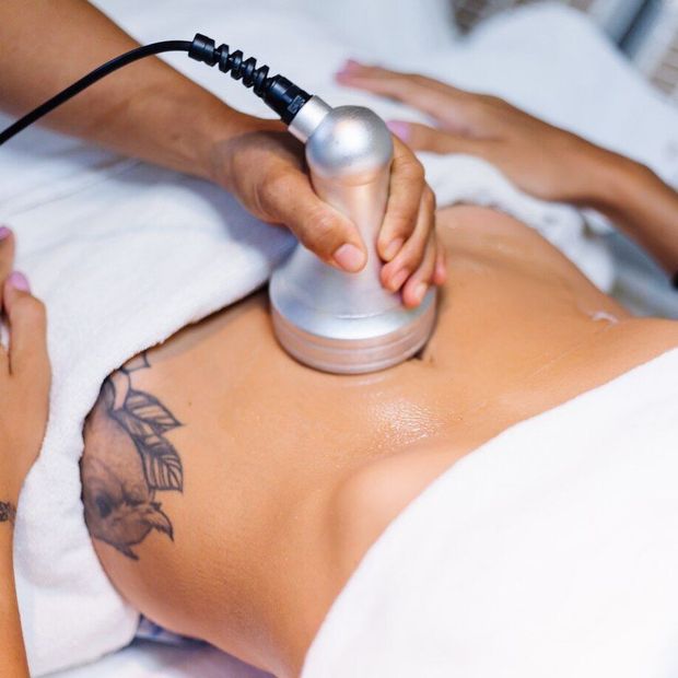 a woman with a tattoo on her stomach is getting a massage