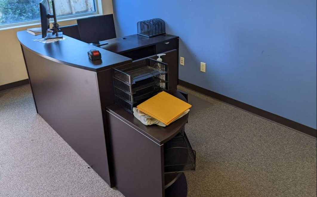 Office desk with open file drawer, yellow folder, and blue walls