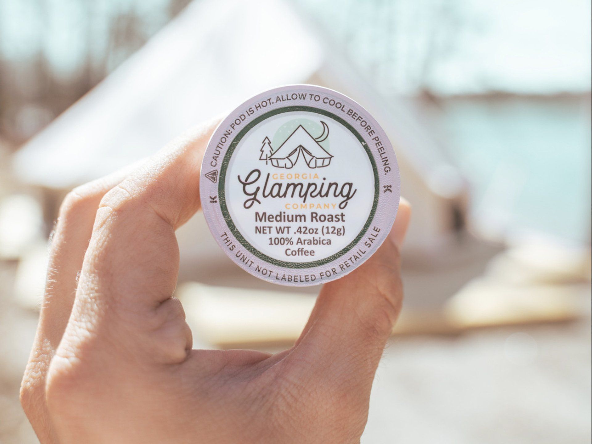 Hand holding a coffee pod labeled 