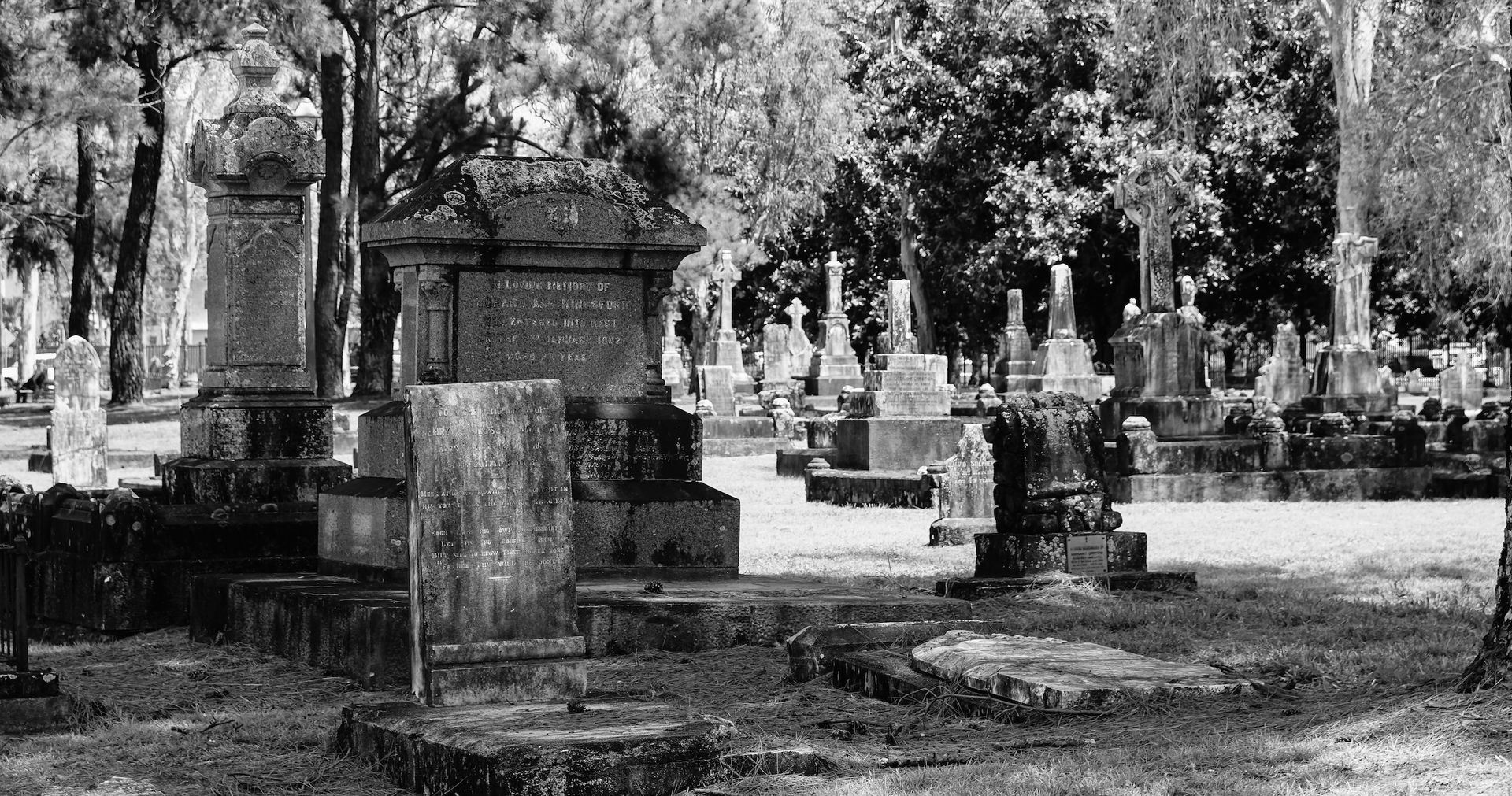 Black and white photograph of historic 19th-century pioneer headstones and graves at the heritage-listed McLeod Street Pioneer Cemetery in Cairns, Queensland, featuring the prominent stone monument of the town's first mayor, Richard Ash Kingsford.