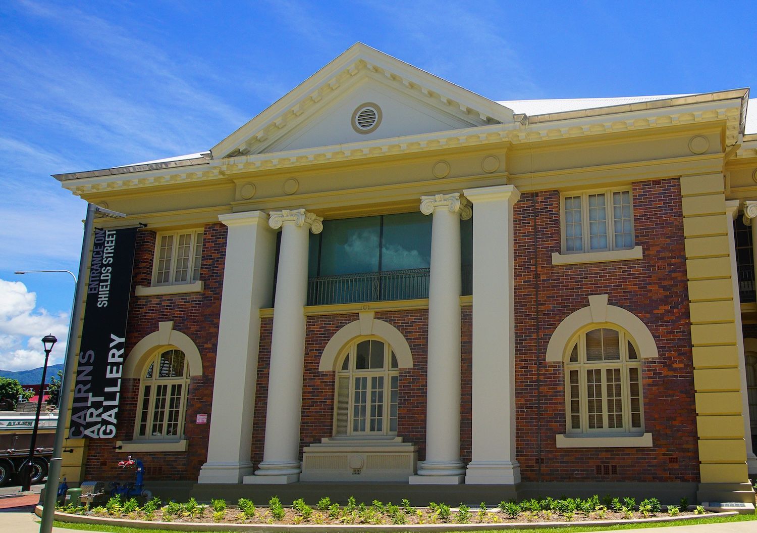 Historic Cairns Art Gallery building on Shields Street in Cairns CBD, Queensland, featuring heritage brick faรงade and classical columns, popular cultural attraction and indoor rainy-day activity for visitors to Cairns and Far North Queensland.