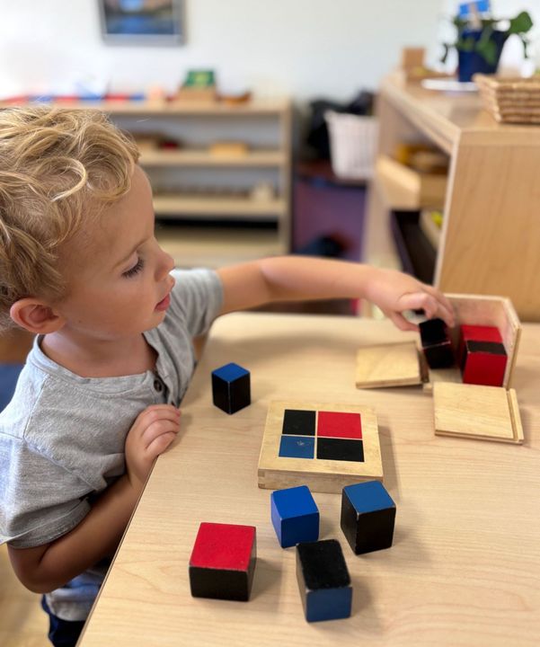 A Montessori child working with binomial cube