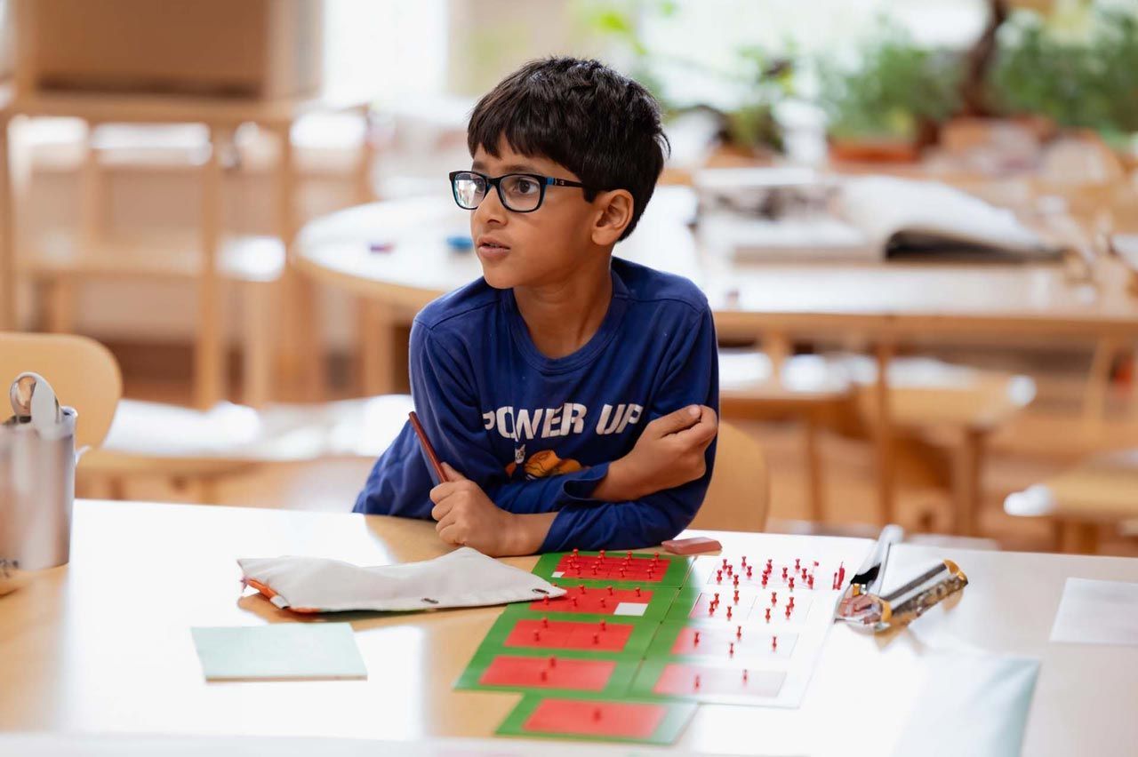 A young Montessori student working with math material.