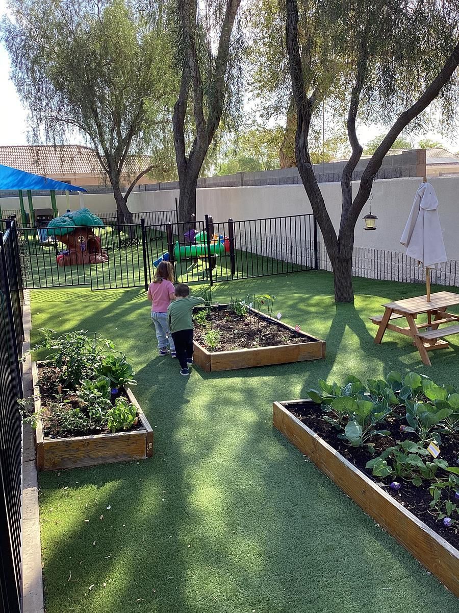 Montessori child working outdoors watering plants.