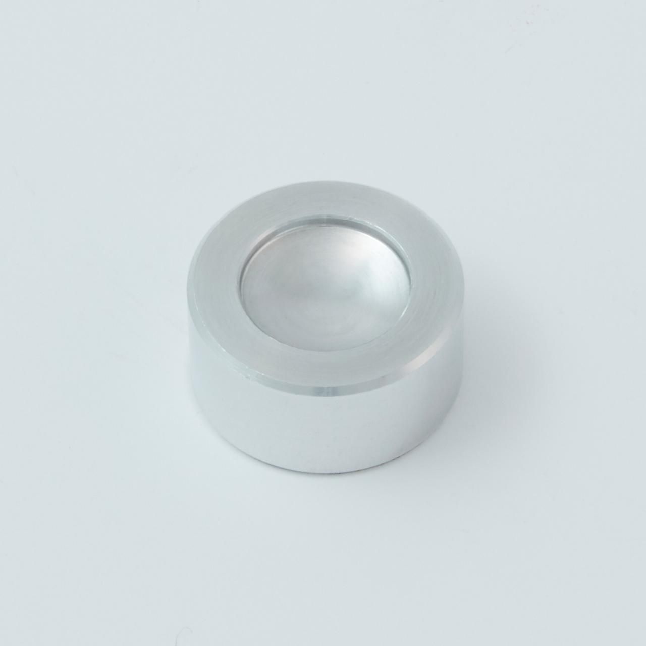 Silver metal cylindrical object with a spherical indentation on top.