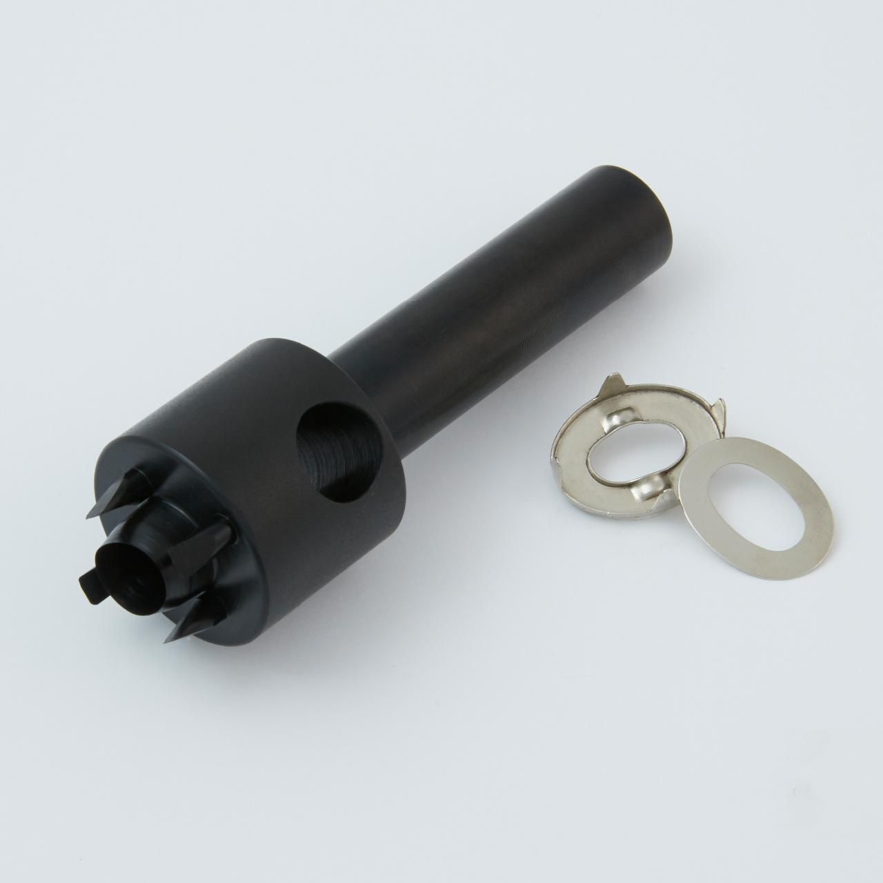 Black tool with a star-shaped head, next to a small metal clip with an eyelet.