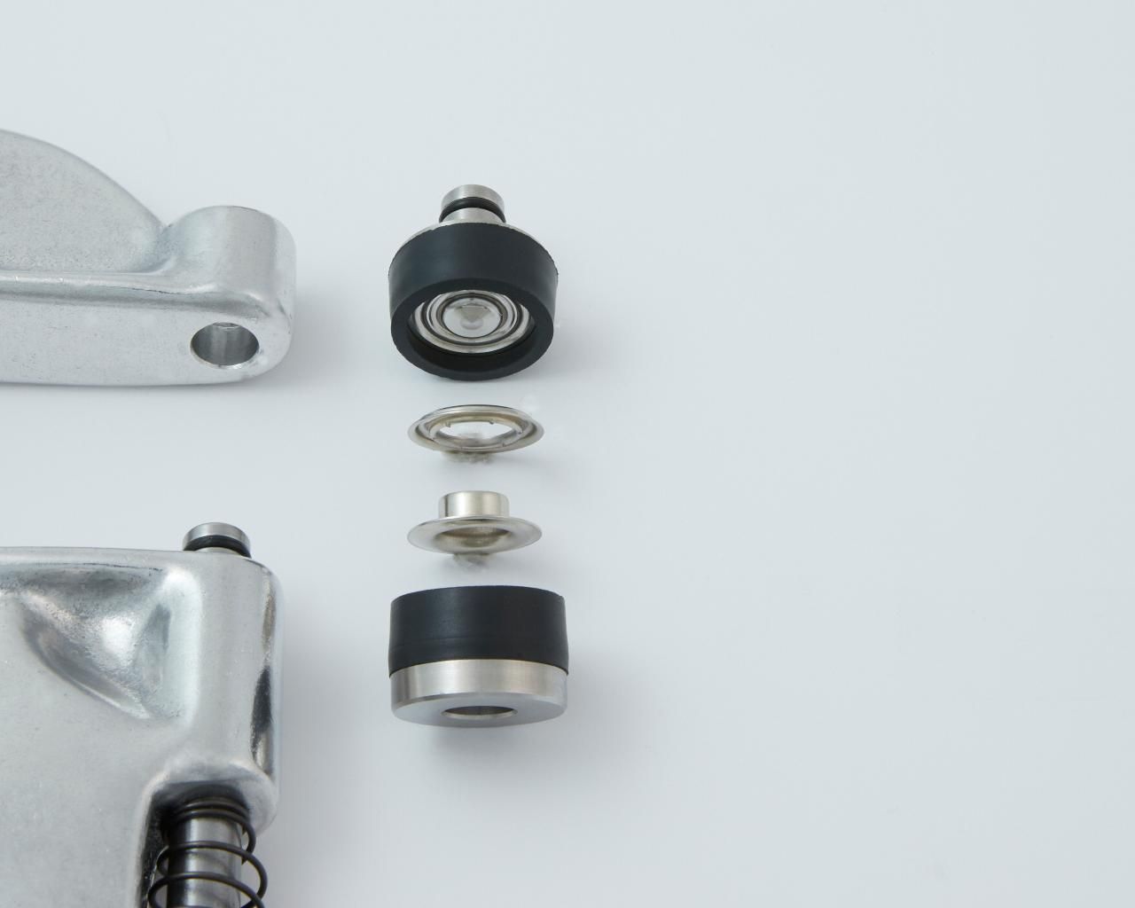 Exploded view of a mechanical component with a roller bearing, washer, and rubber seals.