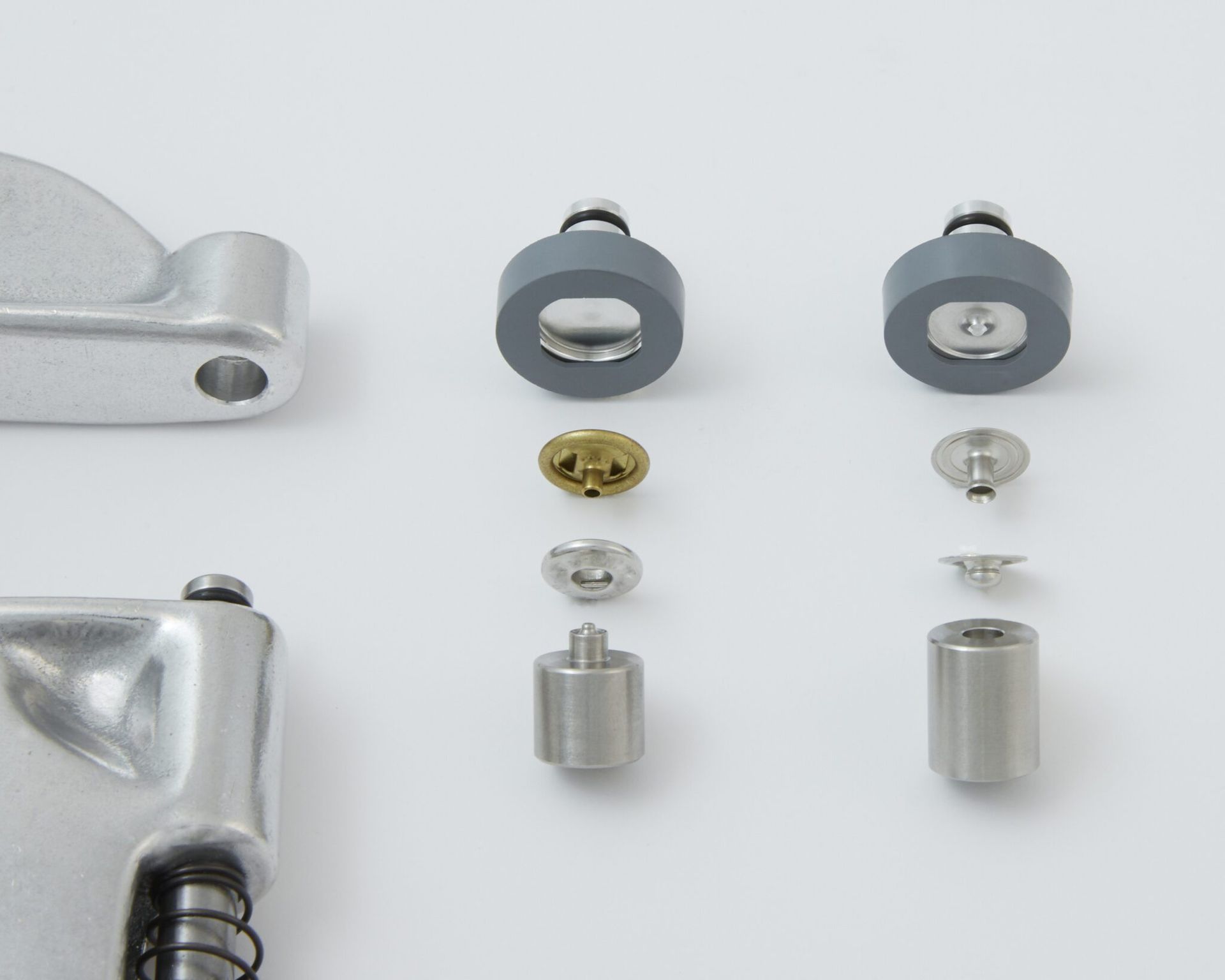 Disassembled metal tool parts: a handle section, screws, and circular components.