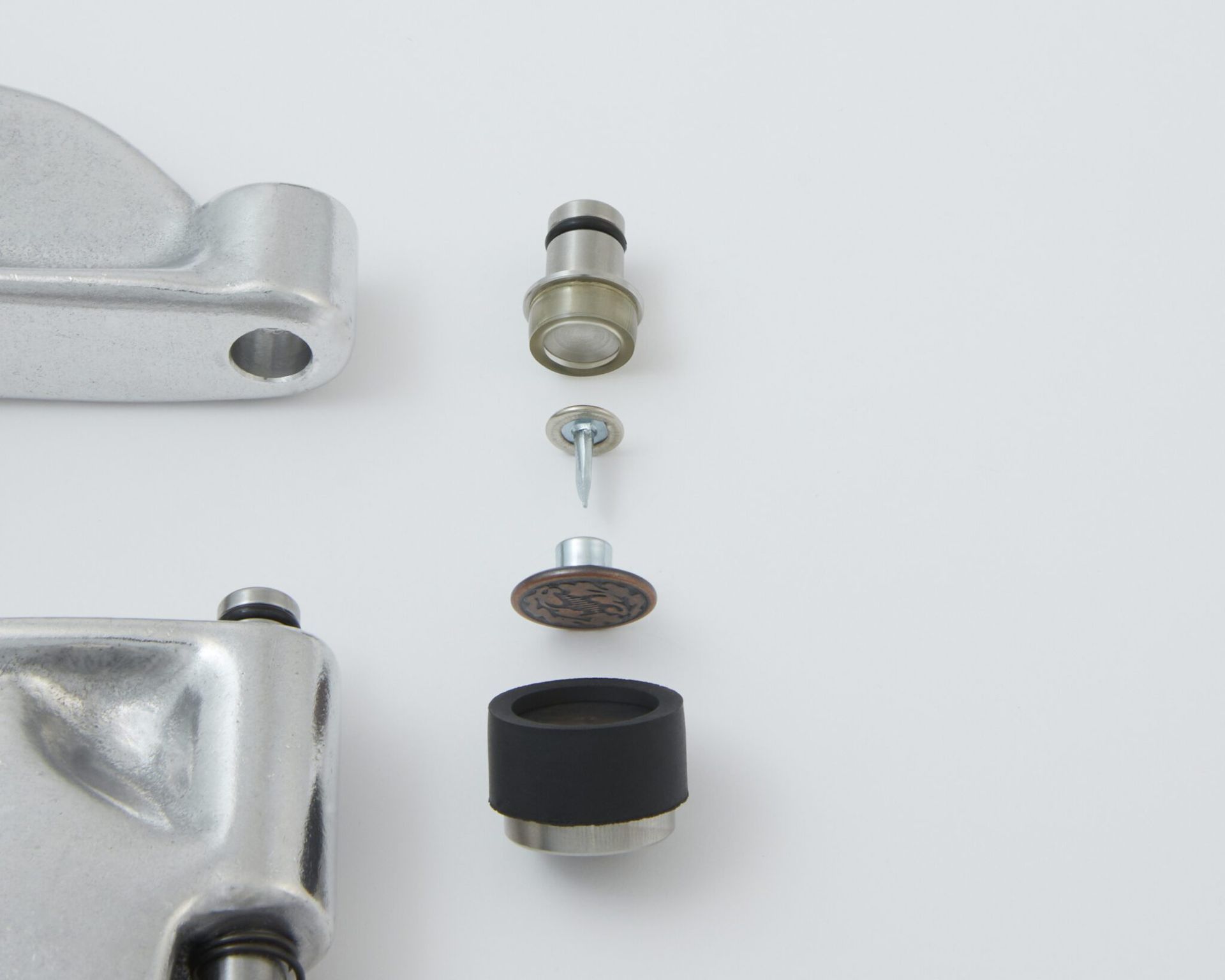 Exploded view of a chrome drum pedal assembly, showing a rod, screws, felt pad, and rubber foot.