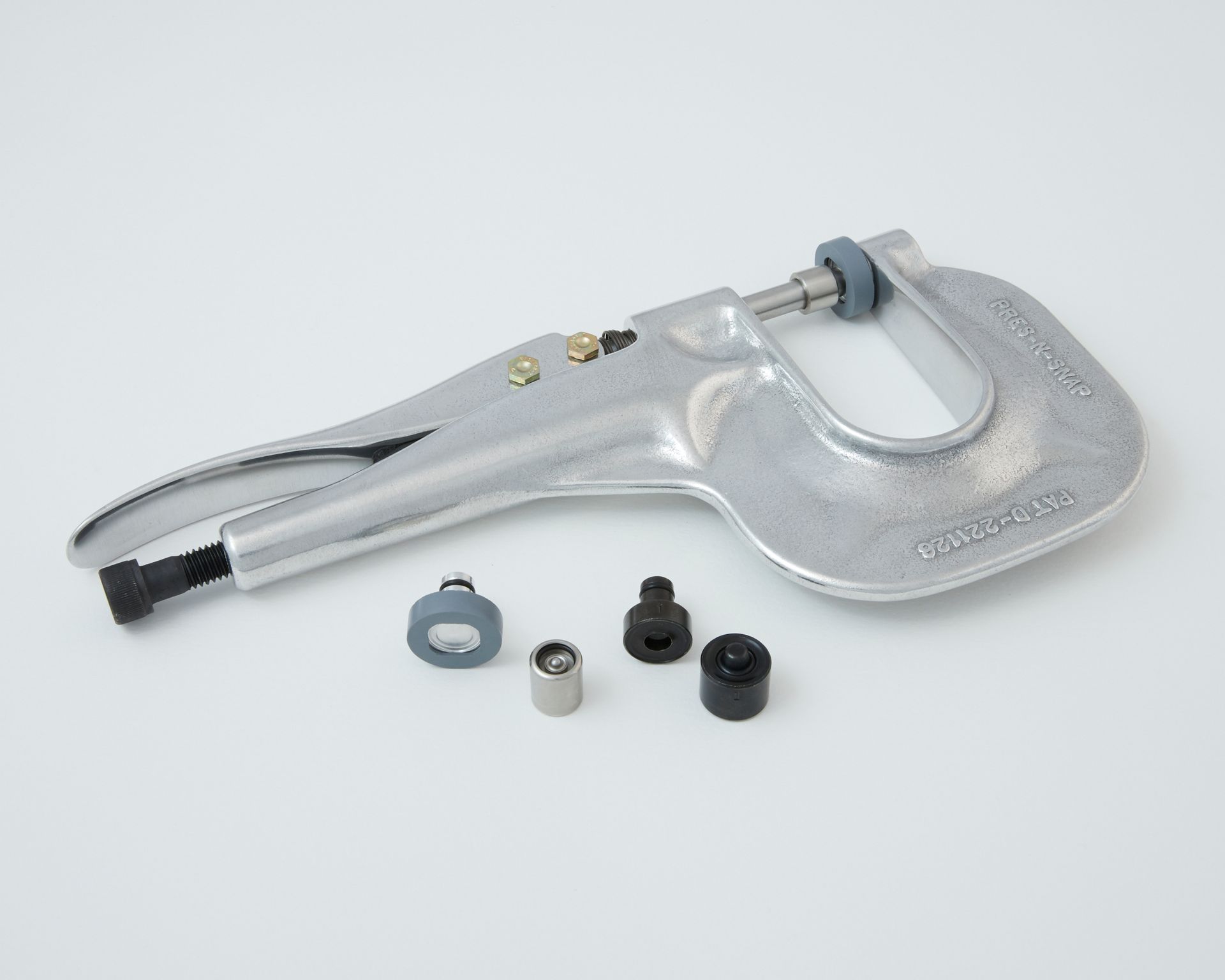 Silver handheld device with attached cable and small accessory parts on a white background
