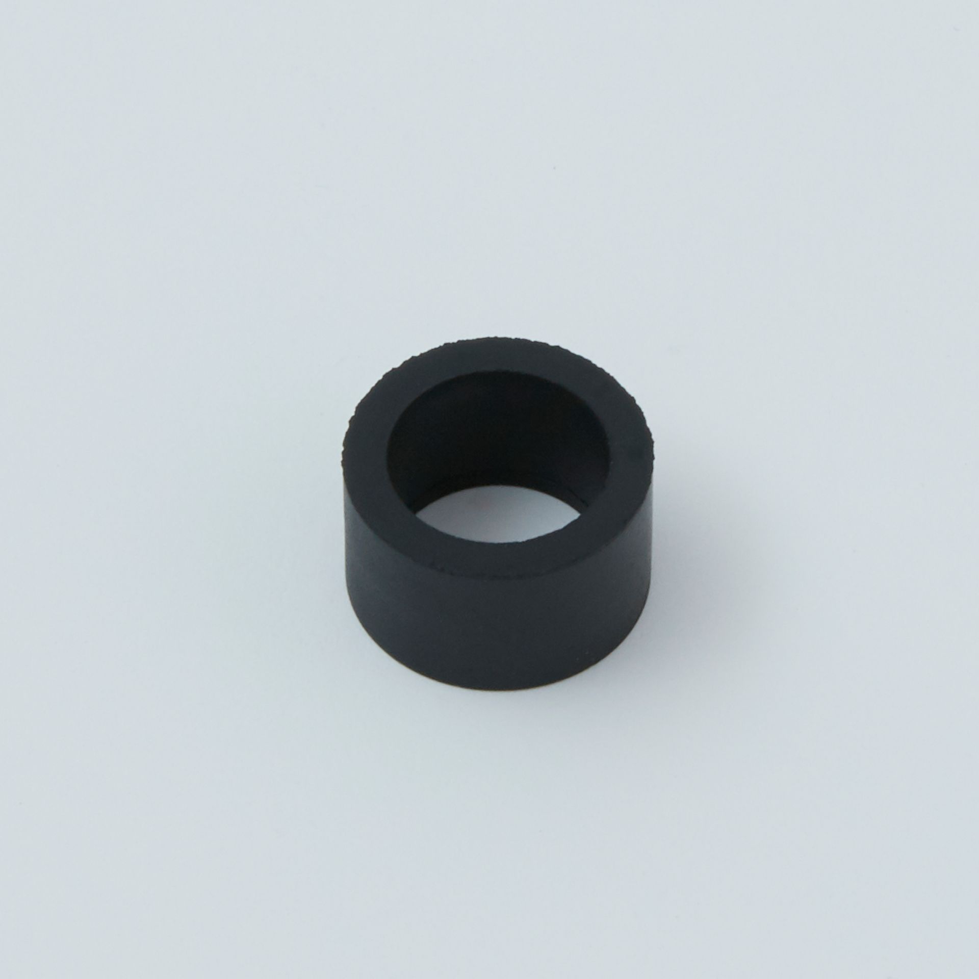Black cylindrical ring on a light gray background