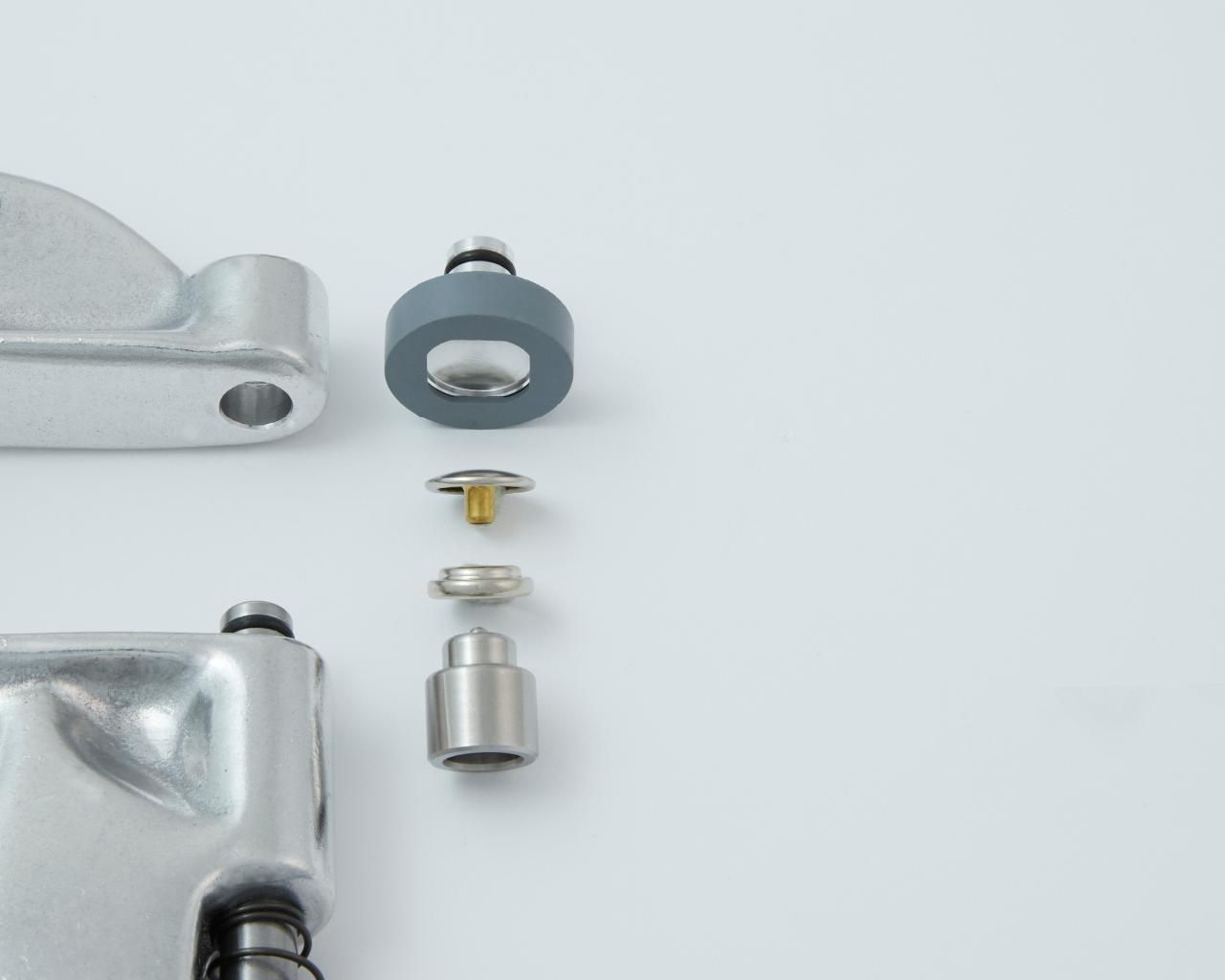 Exploded view of silver metal hardware components, including a washer, screw, and multiple fasteners.