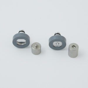 Small gray and silver metal hardware parts arranged on a light background