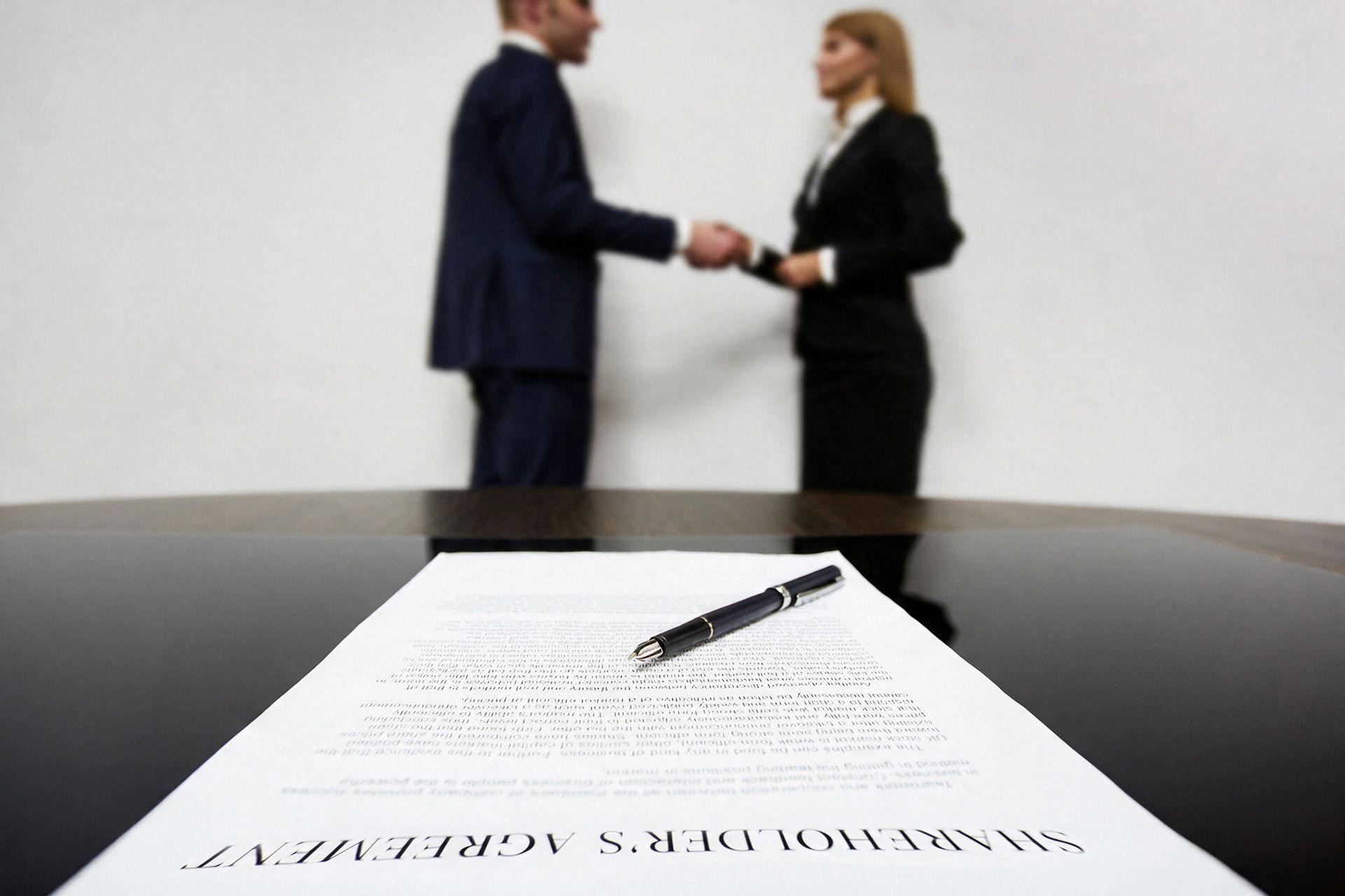 Business owners reviewing shareholders agreement terms