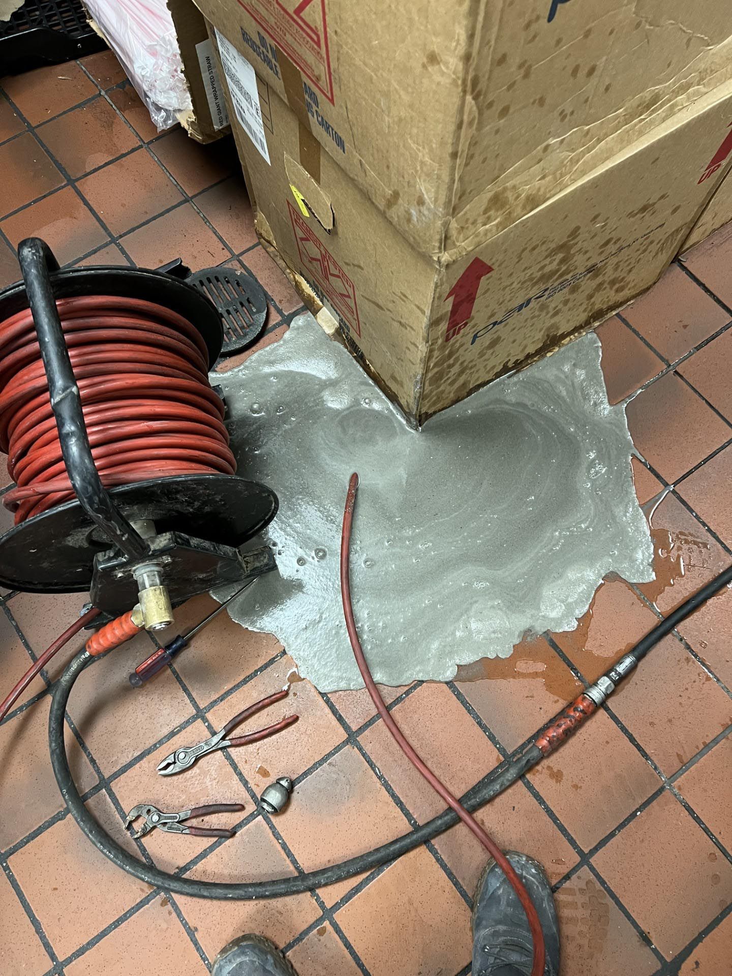 A hose is laying on the floor next to a box.
