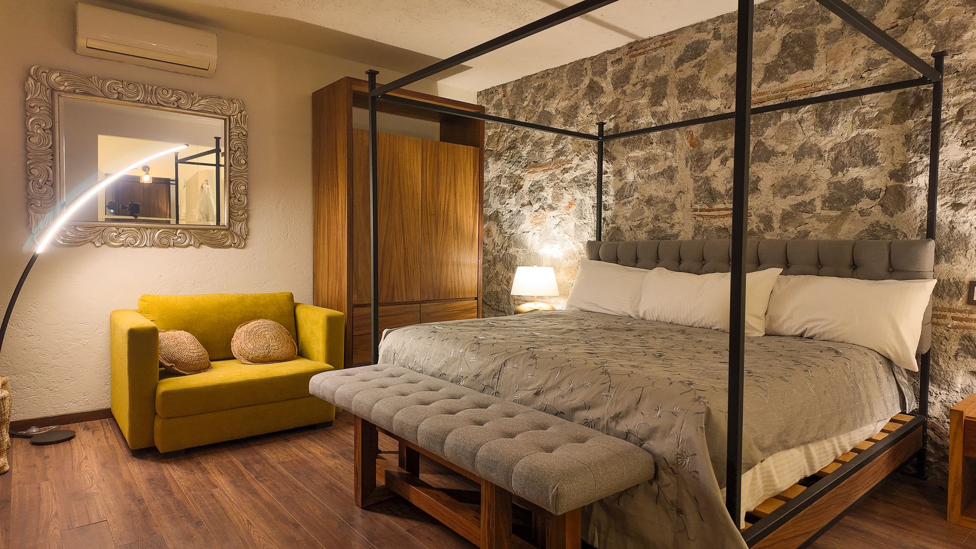 Un dormitorio con una cama con dosel y un sofá amarillo, comodo y elegante.