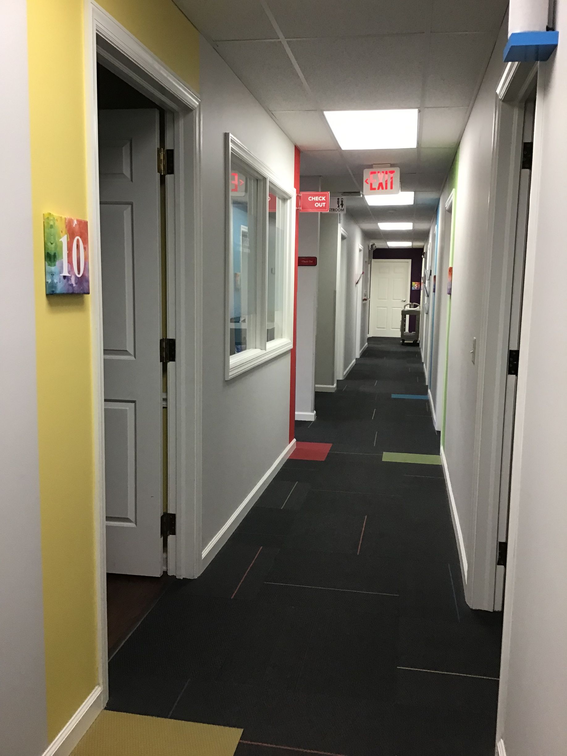 A long hallway with a sign on the wall that says exit