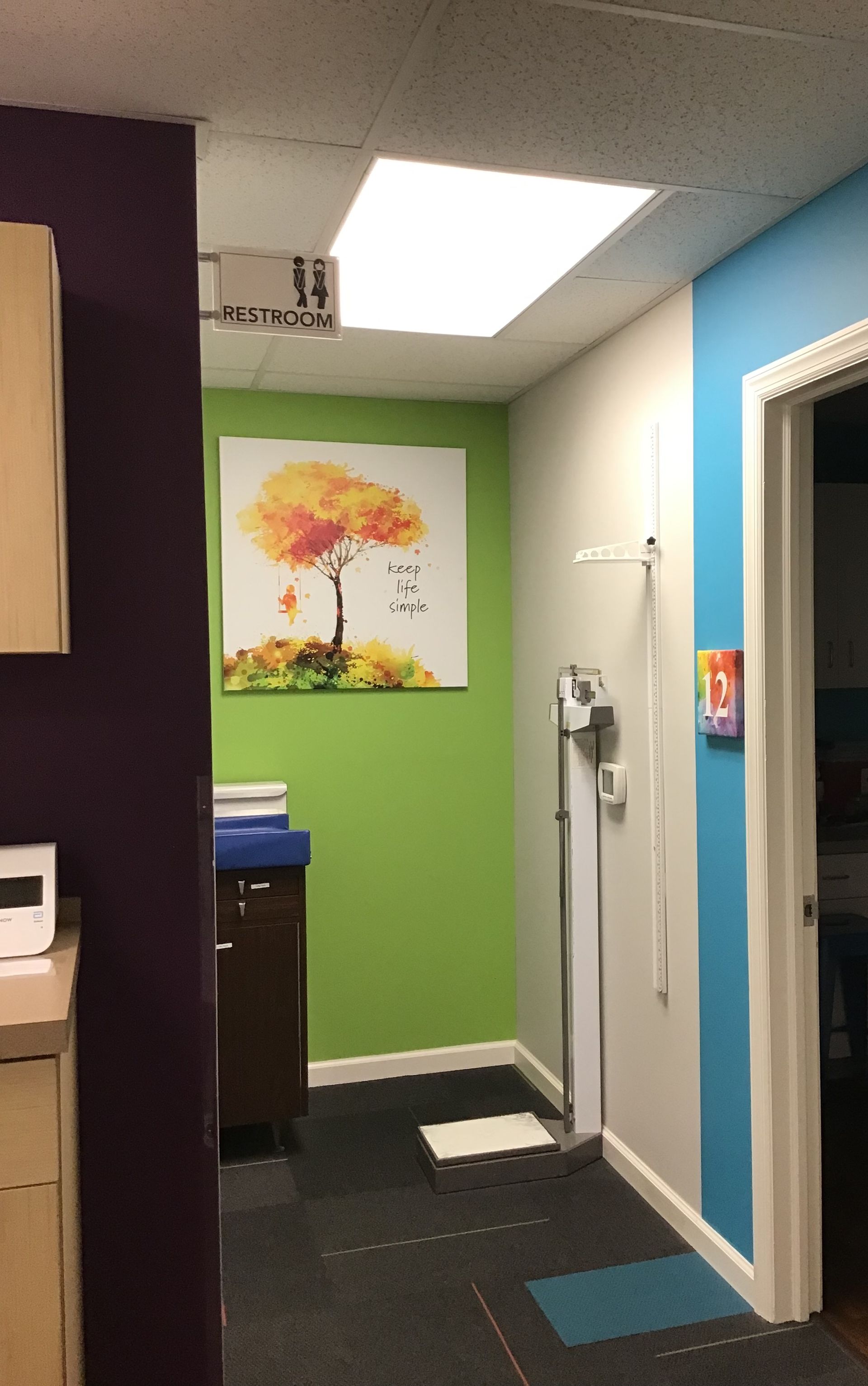 A hallway with a painting of a tree on the wall