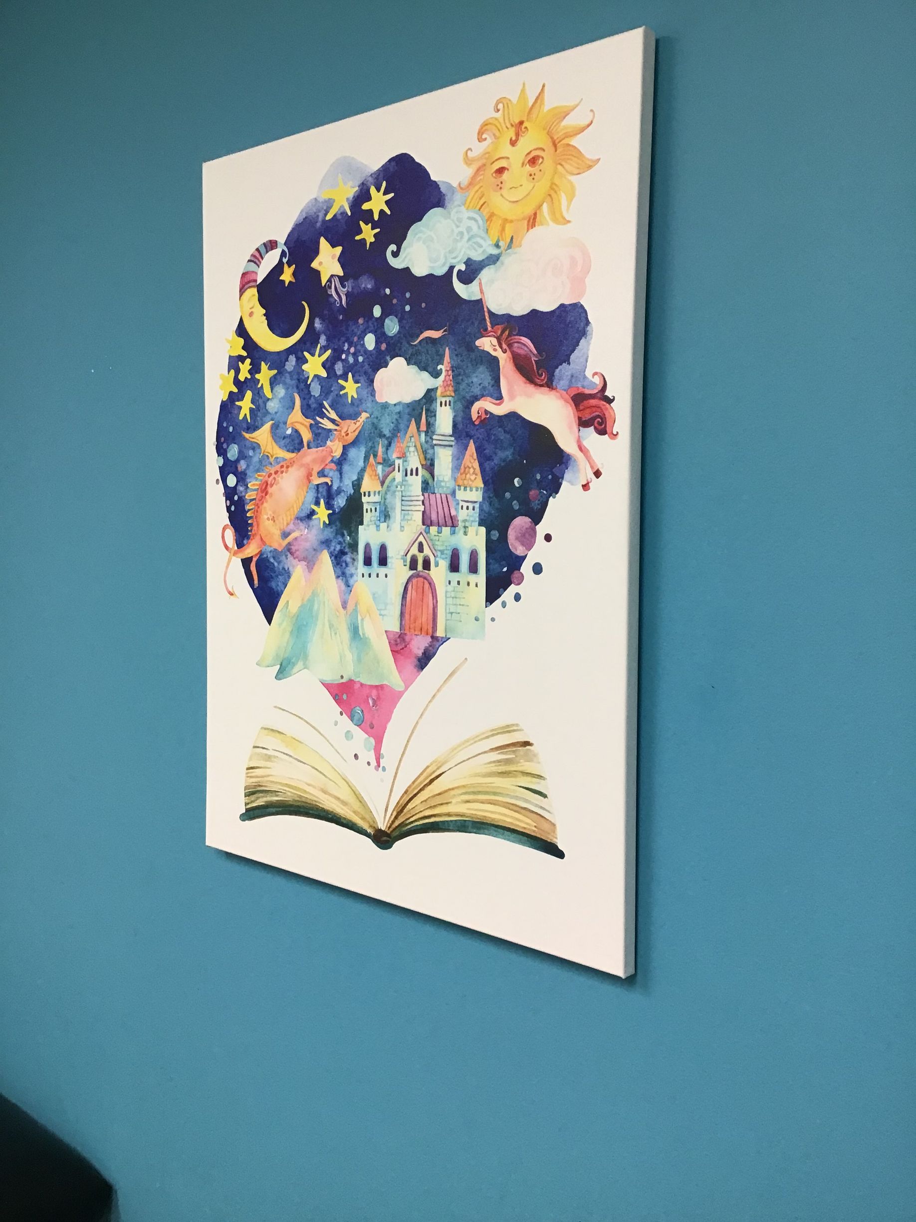 A painting of a castle is hanging on a blue wall