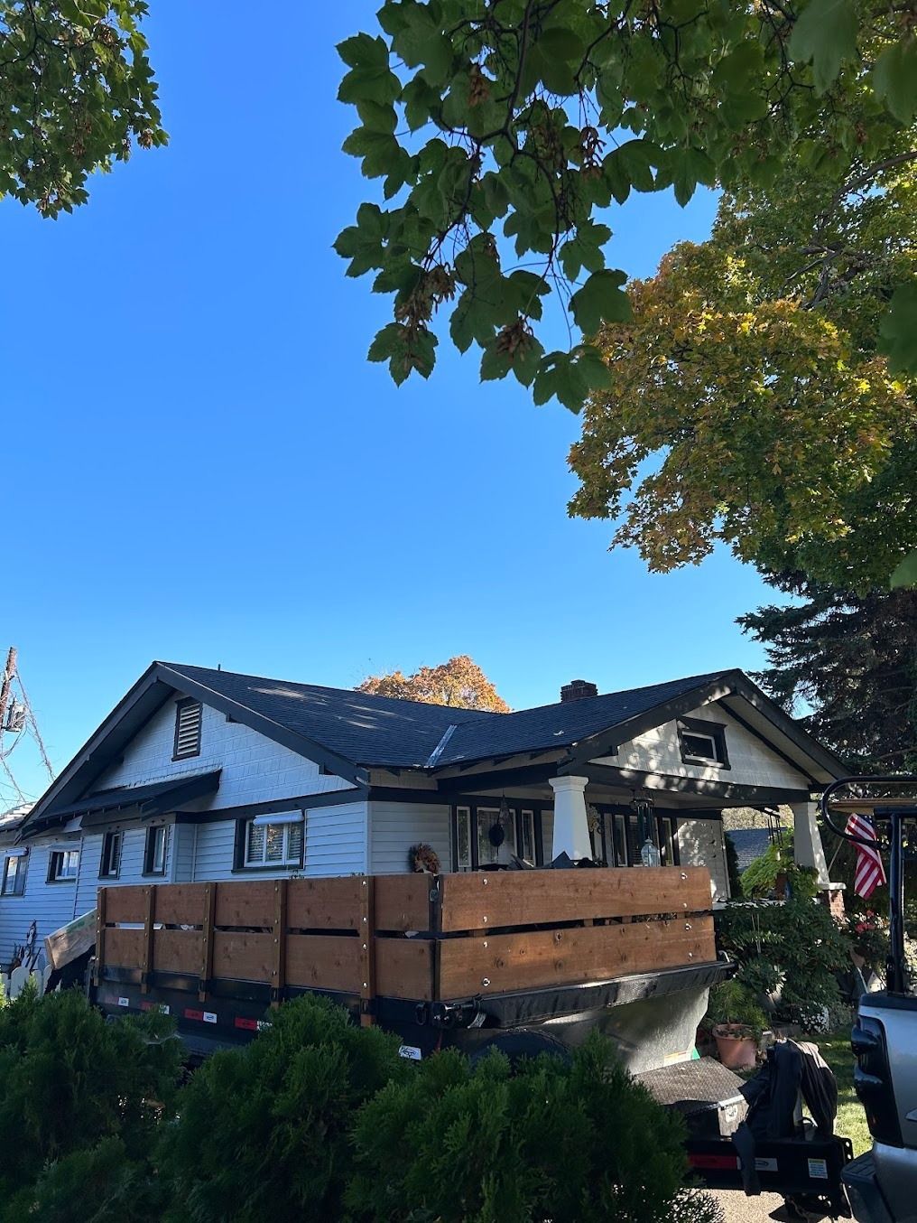 House with wooden balcony under trees on a sunny day
