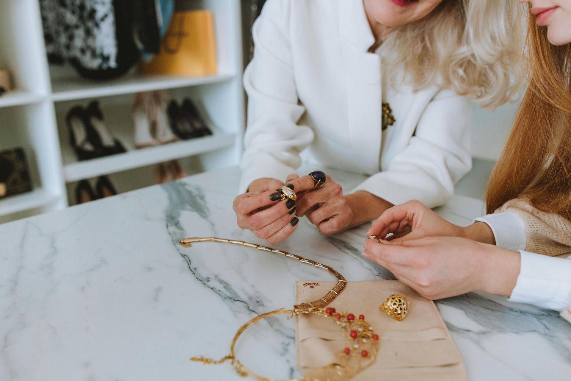 Two women reviewing options for some custom jewelry design they are considering purchasing in Wading River, NY.