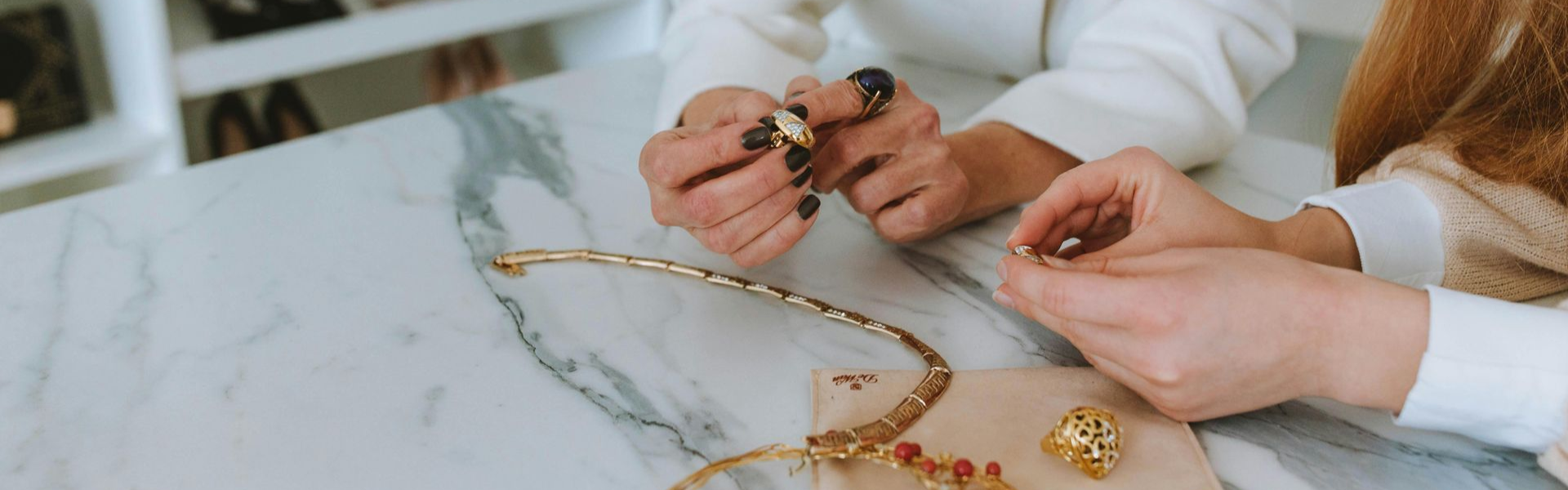 Two women reviewing options for some custom jewelry design they are considering purchasing in Wading River, NY.
