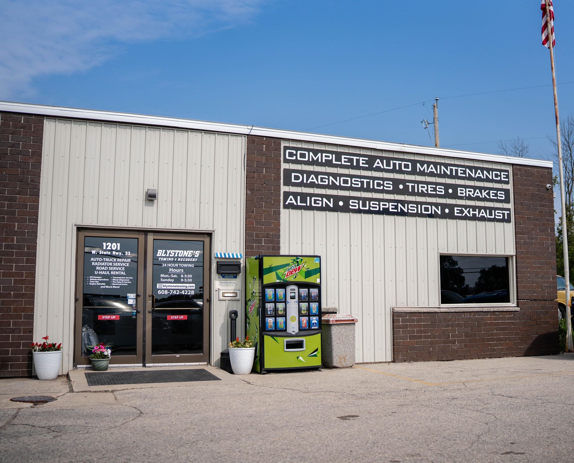 Auto repair shop exterior with sign: Complete Auto Maintenance. Vending machine beside the door.
