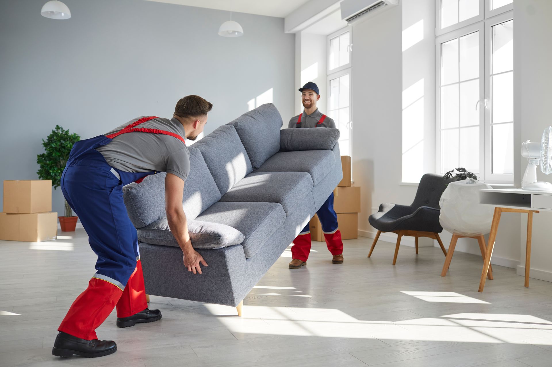two men holding the sofa
