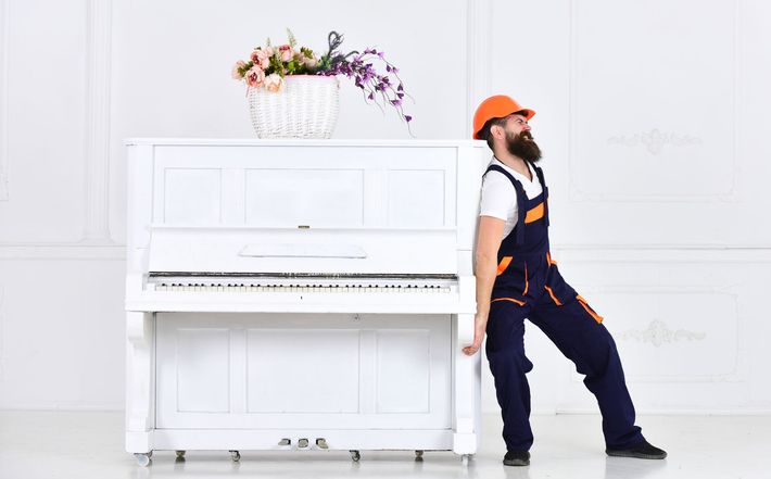 man pushing the piano