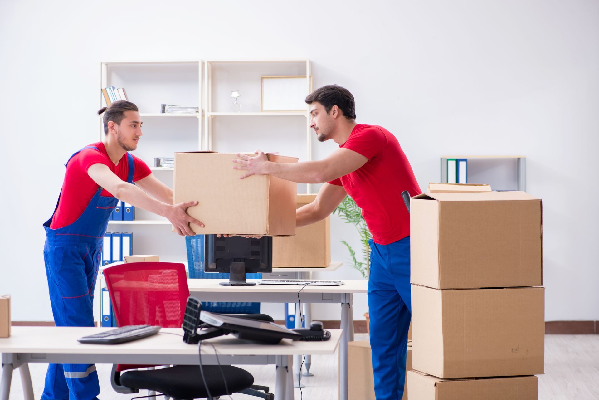 men putting the moving boxes in office room