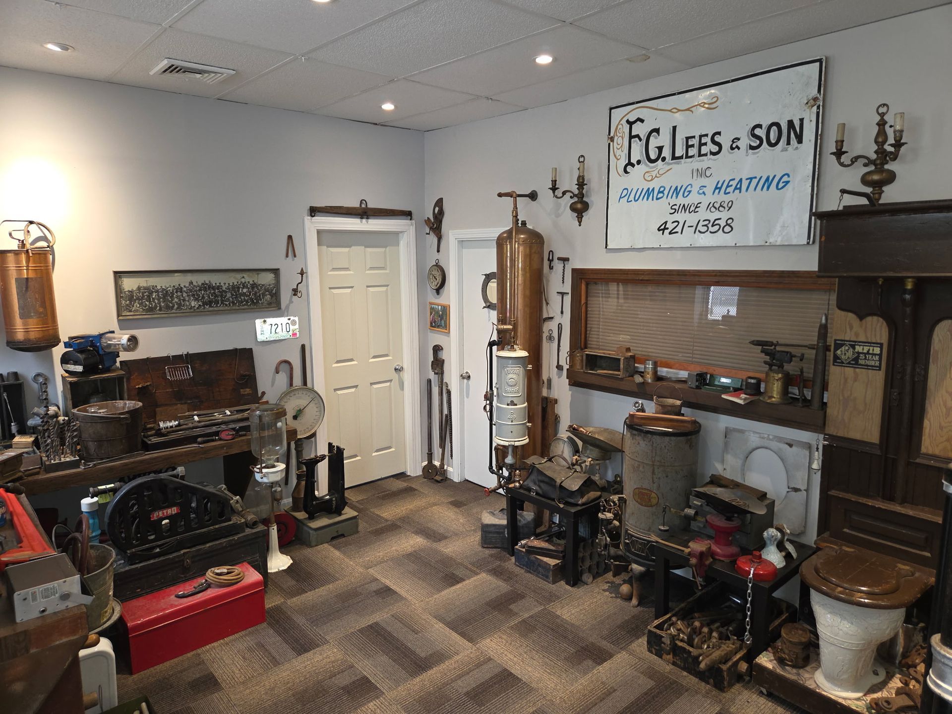 Antique shop interior with vintage furniture, tools, and a large wooden sign on the wall